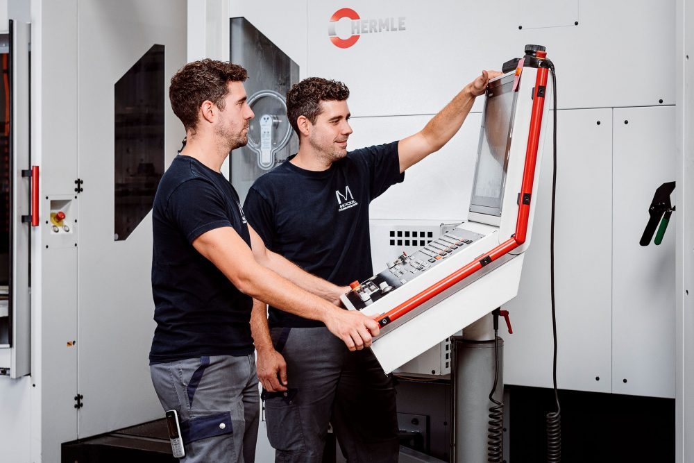 C 400 | Centre de fraisage | Utilisation Deux opérateurs de machine en train d’utiliser le centre de fraisage à commande numérique C 400 avec le manipulateur de palettes HS Flex